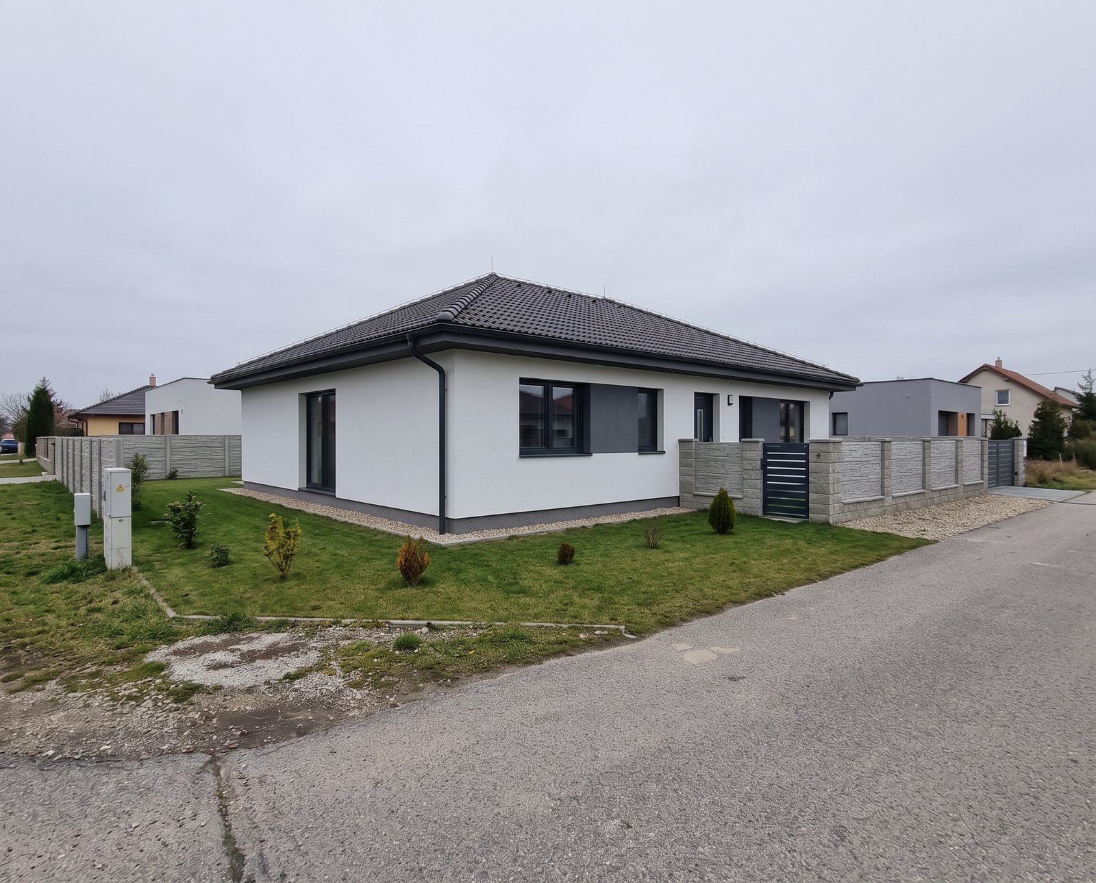 Rodinný dom zvonku pred úpravou, pod zamračenou oblohou